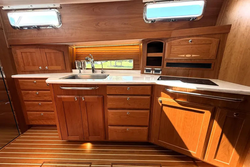 Slide: The Image of Luxurious 2022 Sabre 48 Salon Express yacht kitchen with wood cabinetry and modern appliances. - 29