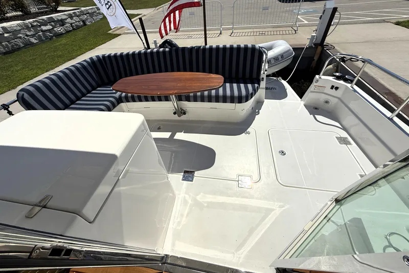 Slide: The Image of 2022 Sabre 48 Salon Express yacht deck with striped seating and wooden table. - 1