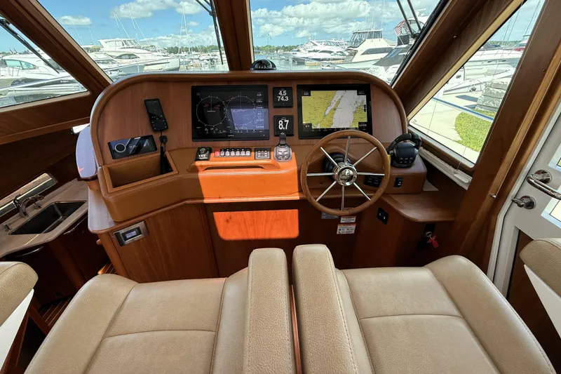 Slide: The Image of 2022 Sabre 48 Salon Express helm with navigation screens and steering wheel. - 23