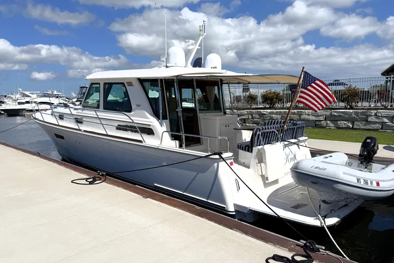 Slide: The Image of 2022 Sabre 48 Salon Express yacht docked, featuring sleek design and American flag. - 51