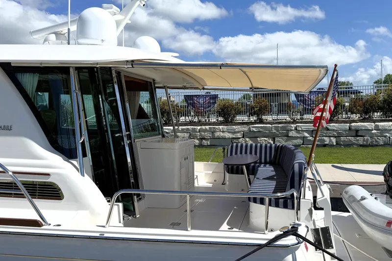 Slide: The Image of 2022 Sabre 48 Salon Express yacht with striped seating and American flag. - 6