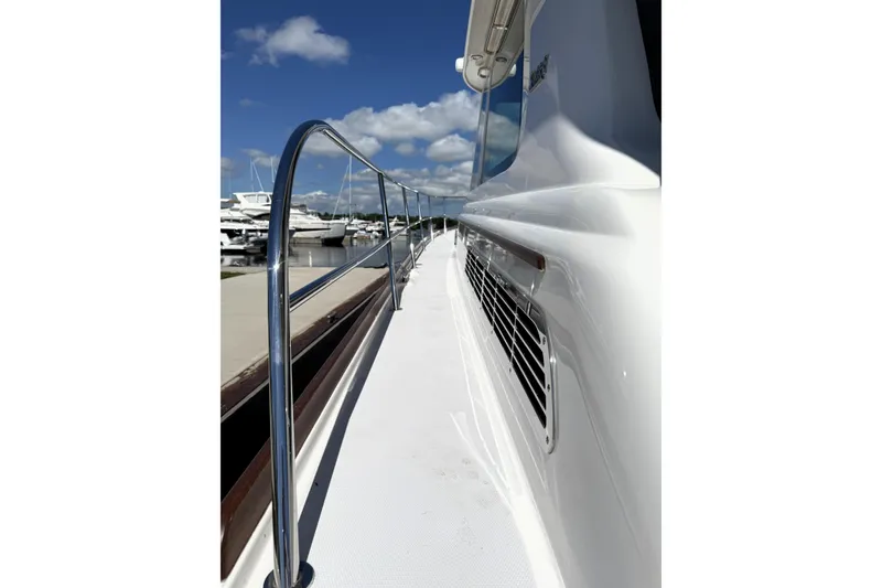 Slide: The Image of 2022 Sabre 48 Salon Express yacht deck with railing, docked under clear blue sky. - 44