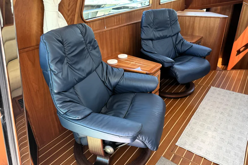 Slide: The Image of Luxurious interior of 2022 Sabre 48 Salon Express with plush blue chairs and wooden accents. - 13