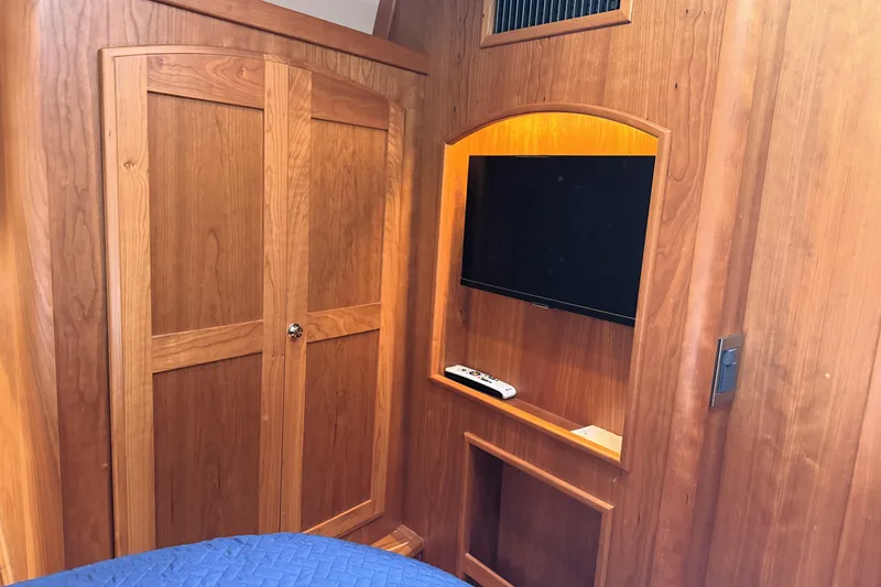 Slide: The Image of Interior of 2022 Sabre 48 Salon Express with wooden cabinetry and mounted TV. - 34