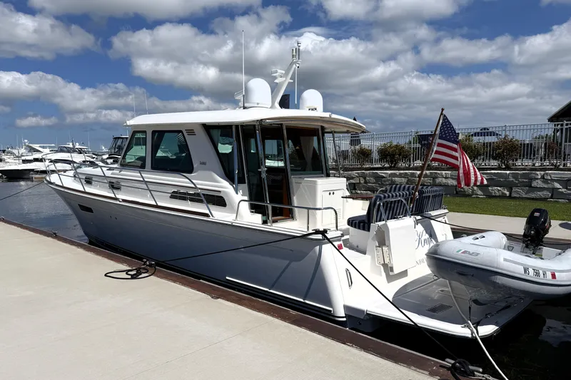 Slide: The Image of 2022 Sabre 48 Salon Express yacht docked, featuring sleek design and American flag. - 5