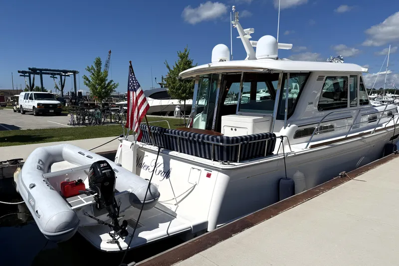 Slide: The Image of 2022 Sabre 48 Salon Express yacht docked with American flag and inflatable boat. - 52