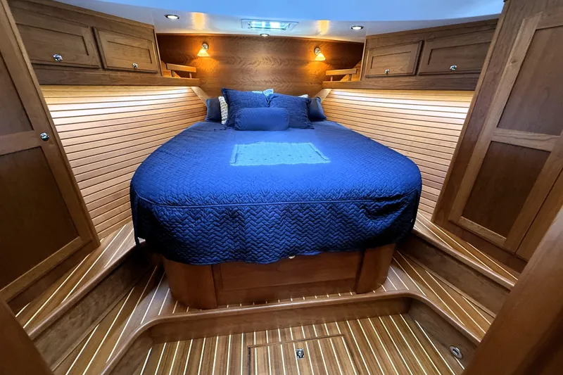 Slide: The Image of Luxurious cabin interior of 2022 Sabre 48 Salon Express with wooden finish and blue bedding. - 36