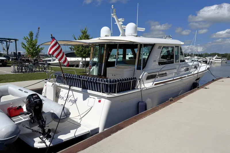 Slide: The Image of 2022 Sabre 48 Salon Express yacht docked, featuring American flag and inflatable boat. - 53