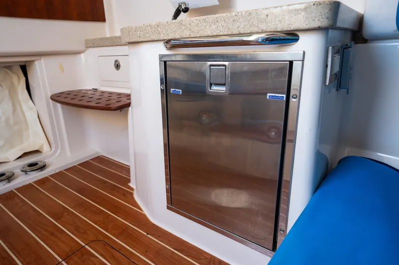 Slide: The Image of 2015 Grady-White Canyon 376 boat interior with stainless steel fridge and wooden flooring. - 29