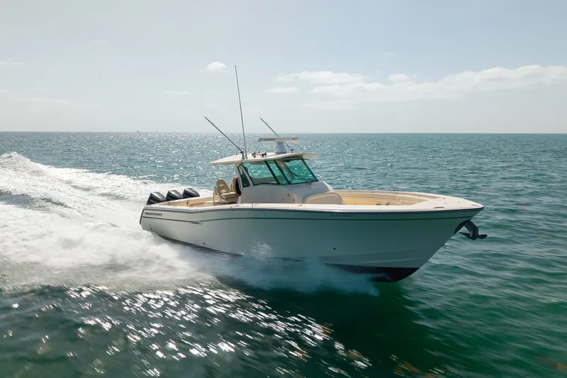 Slide: The Image of 2015 Grady-White Canyon 376 boat cruising on open water, showcasing sleek design and powerful engines. - 13
