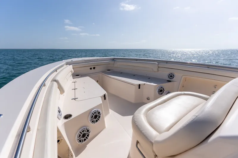 Slide: The Image of 2015 Grady-White Canyon 376 boat interior with ocean view, featuring seating and speakers. - 14