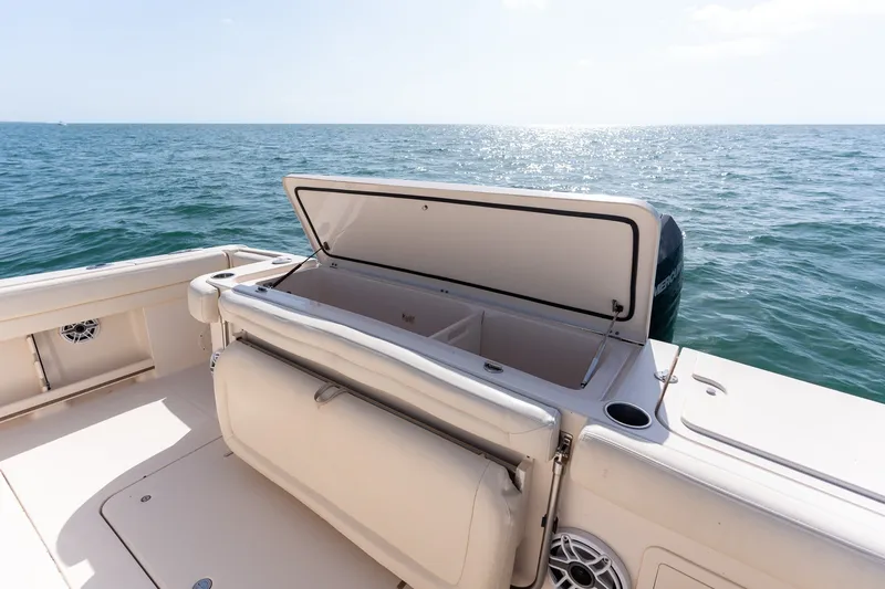 Slide: The Image of 2015 Grady-White Canyon 376 boat with open storage compartment on calm ocean waters. - 32