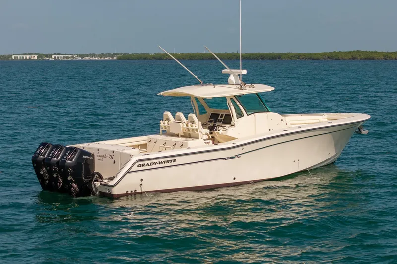 The Image of 2015 Grady-White Canyon 376 boat on calm blue water, featuring triple Mercury engines. - 0