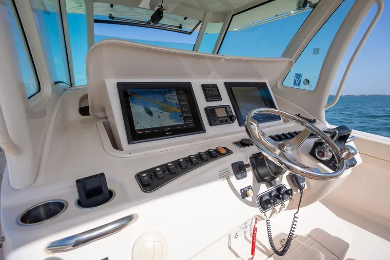 Slide: The Image of Helm of 2015 Grady-White Canyon 376 boat with navigation screens and steering wheel. - 20