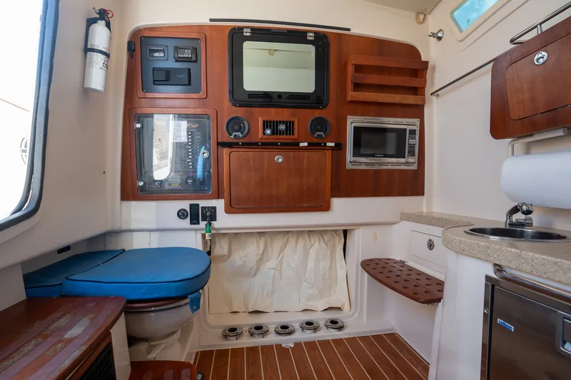 Slide: The Image of Interior of 2015 Grady-White Canyon 376 boat with kitchenette and control panel. - 28
