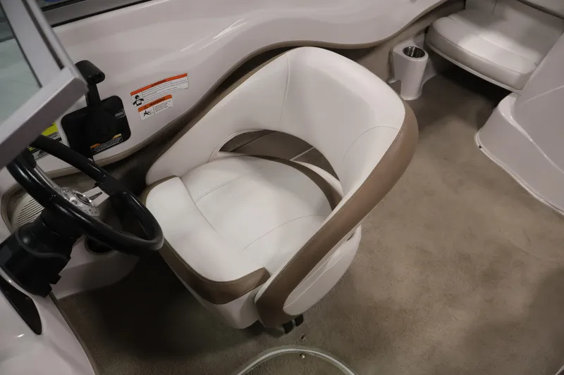 Slide: The Image of 2009 Four Winns H180 boat interior with white and beige seating and steering wheel. - 23