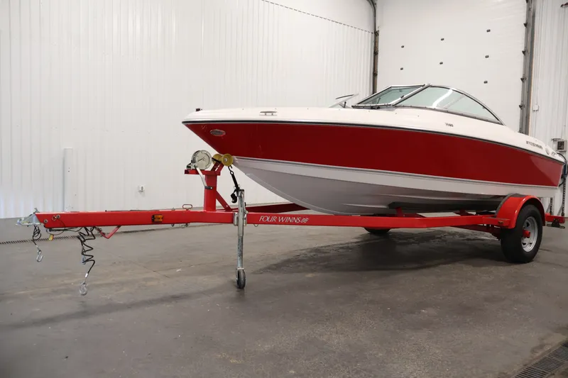 Slide: The Image of 2009 Four Winns H180 boat on red trailer in indoor storage. - 42