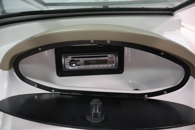 Slide: The Image of 2009 Four Winns H180 boat dashboard with stereo system and storage compartment. - 26