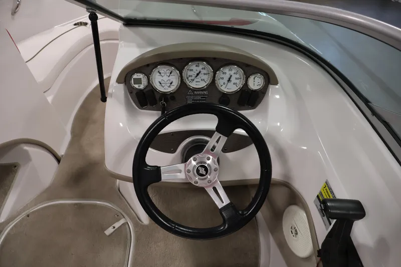 Slide: The Image of 2009 Four Winns H180 boat dashboard with steering wheel and gauges. - 17