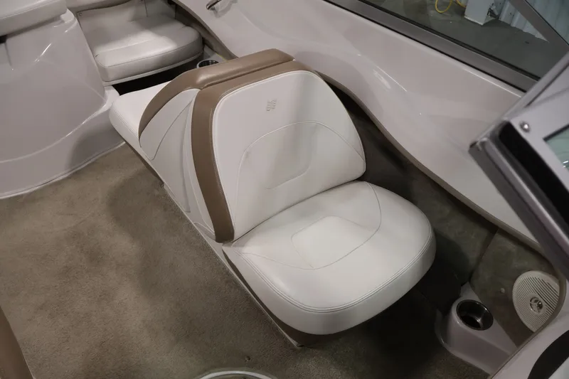 Slide: The Image of Interior seating of a 2009 Four Winns H180 boat, featuring white and tan upholstery. - 28