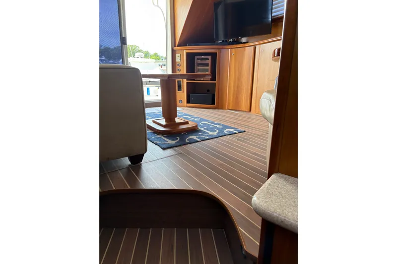 Slide: The Image of Interior of 2001 Silverton 42 Convertible yacht with wood flooring and modern furnishings. - 13