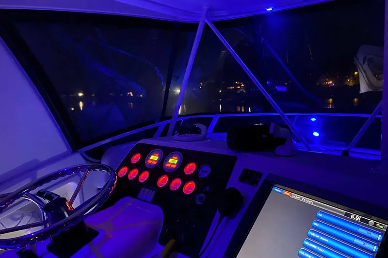 Slide: The Image of Cockpit of 2001 Silverton 42 Convertible yacht illuminated with blue lights at night. - 28