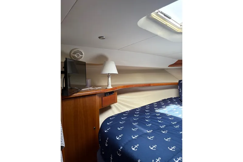 Slide: The Image of Interior of 2001 Silverton 42 Convertible yacht with nautical-themed bedding and wooden cabinetry. - 17