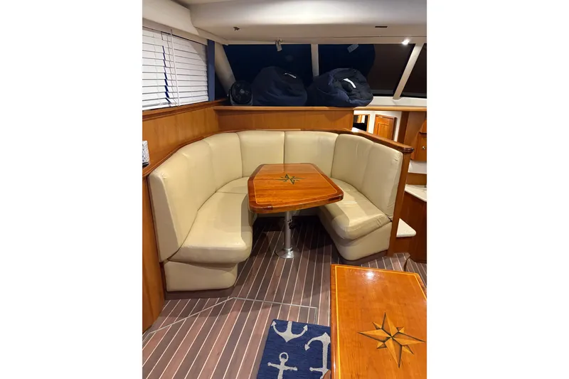 Slide: The Image of Luxurious 2001 Silverton 42 Convertible yacht interior with elegant seating and wooden table. - 14