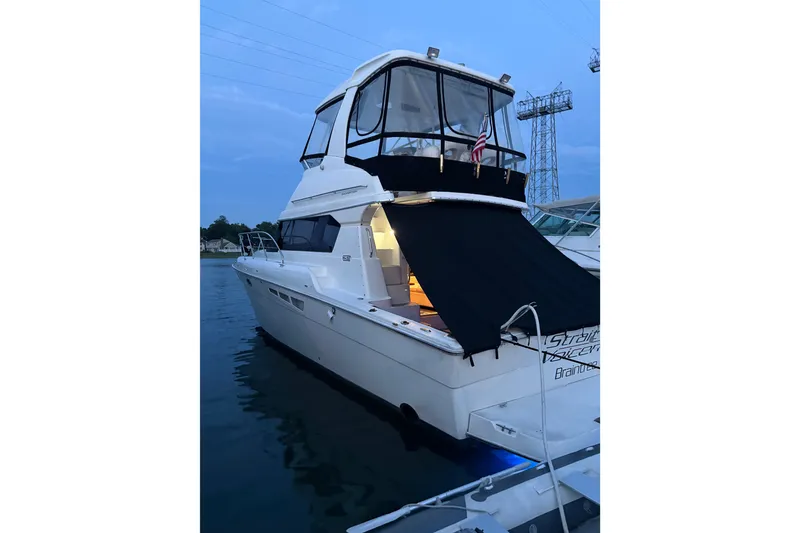The Image of 2001 Silverton 42 Convertible yacht docked at sunset, featuring a sleek design and covered deck. - 10