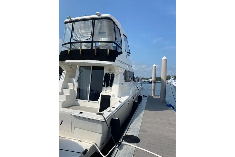 Slide: The Image of 2001 Silverton 42 Convertible yacht docked at marina under clear blue sky. - 6