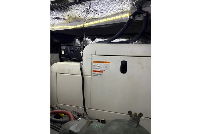 Slide: The Image of Engine room of a 2001 Silverton 42 Convertible boat with visible generator and wiring. - 34