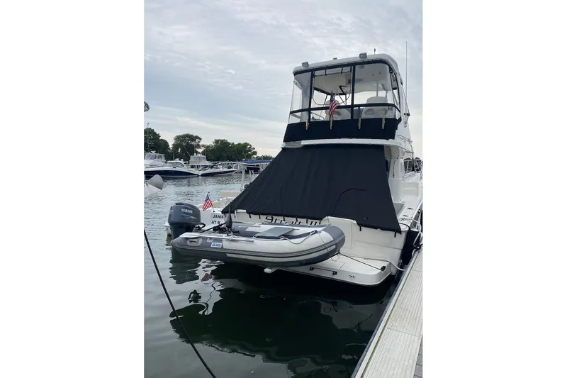 Slide: The Image of 2001 Silverton 42 Convertible yacht docked with inflatable boat attached. - 4