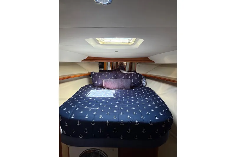 Slide: The Image of Cozy cabin interior of 2001 Silverton 42 Convertible with nautical-themed bedding. - 16