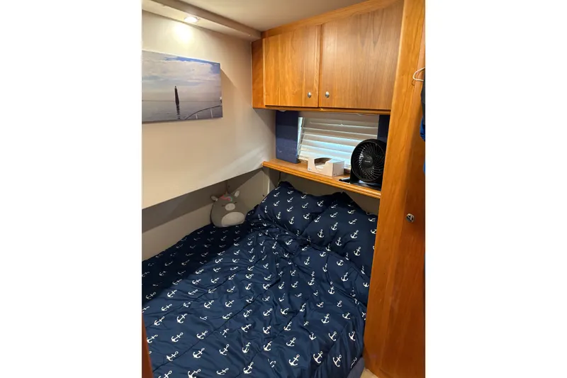 Slide: The Image of Cozy cabin interior of 2001 Silverton 42 Convertible with nautical-themed bedding. - 19