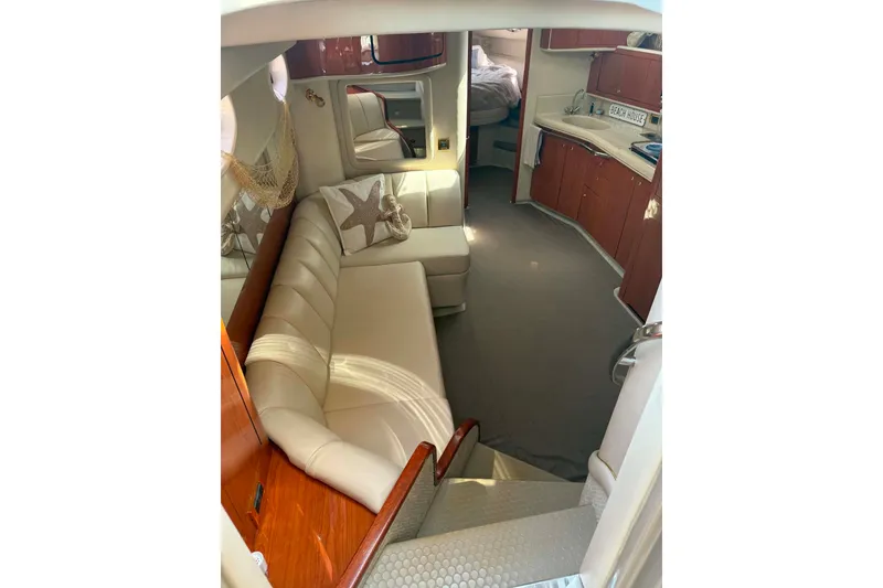 Slide: The Image of Interior of 1999 Sea Ray 450 Sundancer yacht with beige seating and wooden cabinetry. - 17