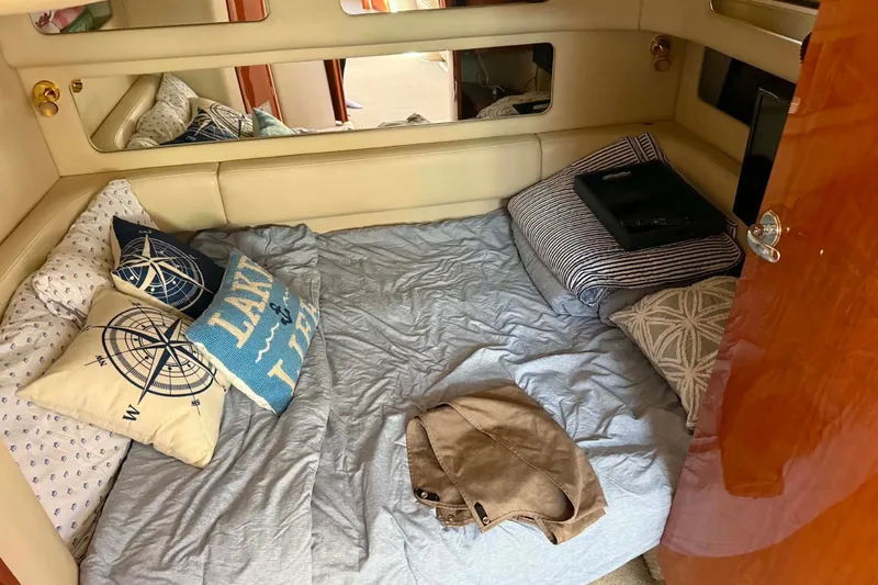 Slide: The Image of Cozy cabin interior of 1999 Sea Ray 450 Sundancer with nautical-themed pillows. - 19