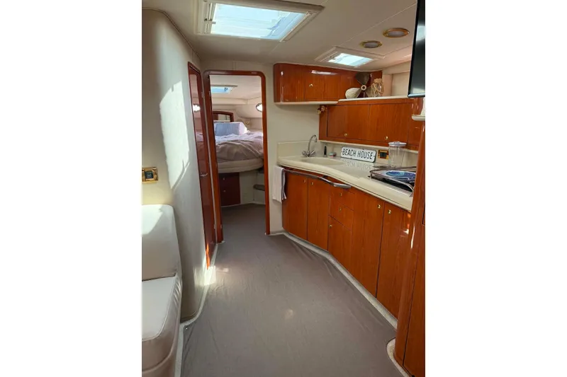 Slide: The Image of 1999 Sea Ray 450 Sundancer interior with wood cabinetry and cozy bedroom. - 22