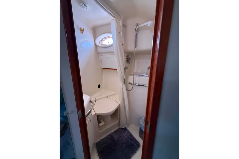 Slide: The Image of Compact bathroom in 1999 Sea Ray 450 Sundancer yacht, featuring shower and toilet. - 16