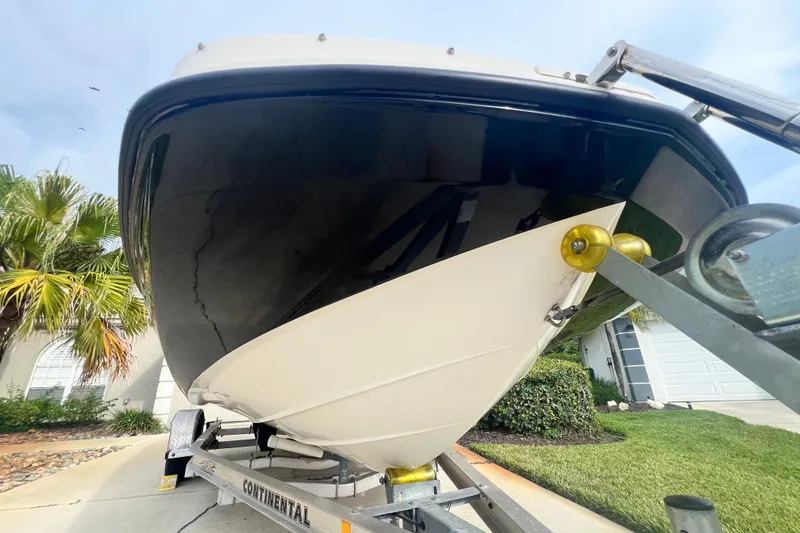 Slide: The Image of 2017 Bayliner 190 Deck Boat on trailer, parked in driveway near palm trees. - 7