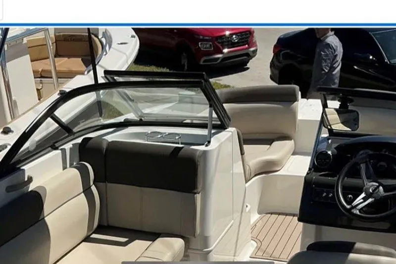 Slide: The Image of 2017 Bayliner 190 Deck Boat interior with beige seating and steering console. - 6