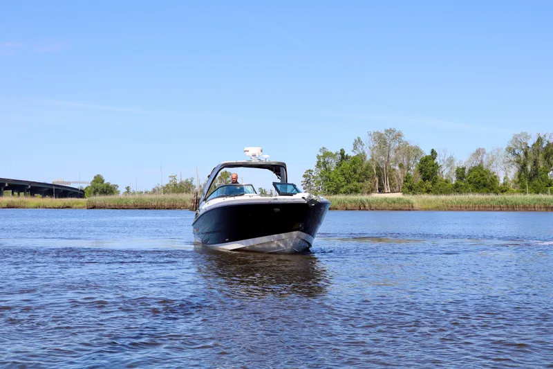 Slide: The Image of 2014 Monterey 328SS Super Sport boat cruising on a calm river under clear blue skies. - 16