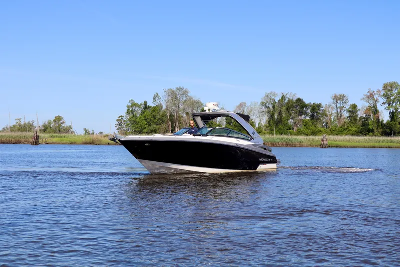 Slide: The Image of 2014 Monterey 328SS Super Sport boat cruising on a calm river under clear blue skies. - 14