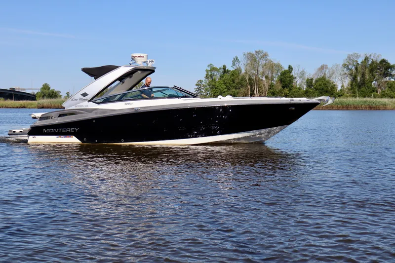 Slide: The Image of 2014 Monterey 328SS Super Sport boat cruising on a calm river. - 19