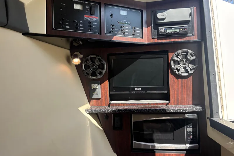 Slide: The Image of Interior of a 2014 Monterey 328SS Super Sport boat with control panel, TV, and microwave. - 32