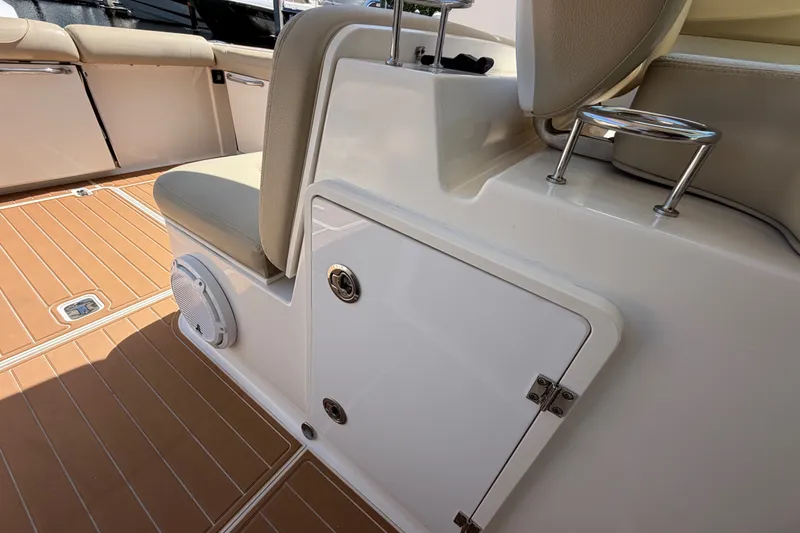 Slide: The Image of 2016 Pursuit DC 325 Dual Console boat interior with seating and storage compartment. - 25
