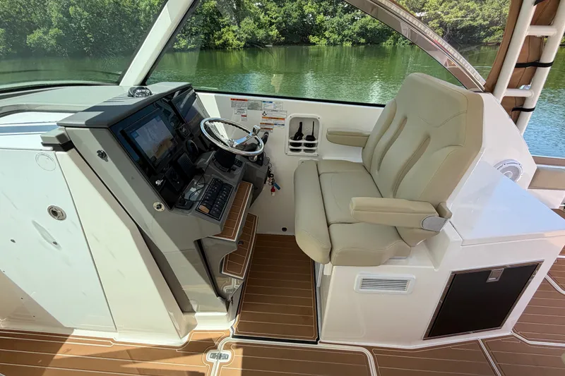 Slide: The Image of 2016 Pursuit DC 325 Dual Console helm with beige captain's seat and modern controls. - 29