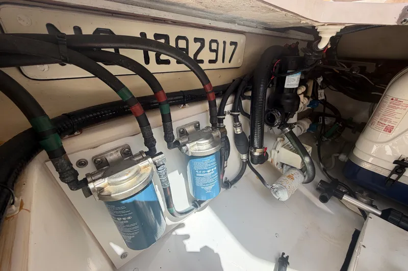 Slide: The Image of Engine compartment of a 2016 Pursuit DC 325 Dual Console with visible fuel filters and hoses. - 57