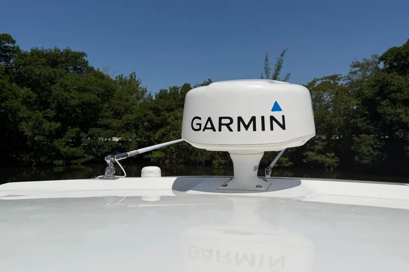 Slide: The Image of Garmin radar on 2016 Pursuit DC 325 Dual Console boat, surrounded by lush greenery. - 53