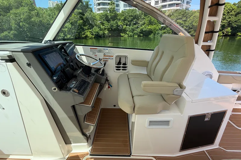 Slide: The Image of Helm of 2016 Pursuit DC 325 Dual Console boat with luxurious seating and modern controls. - 28