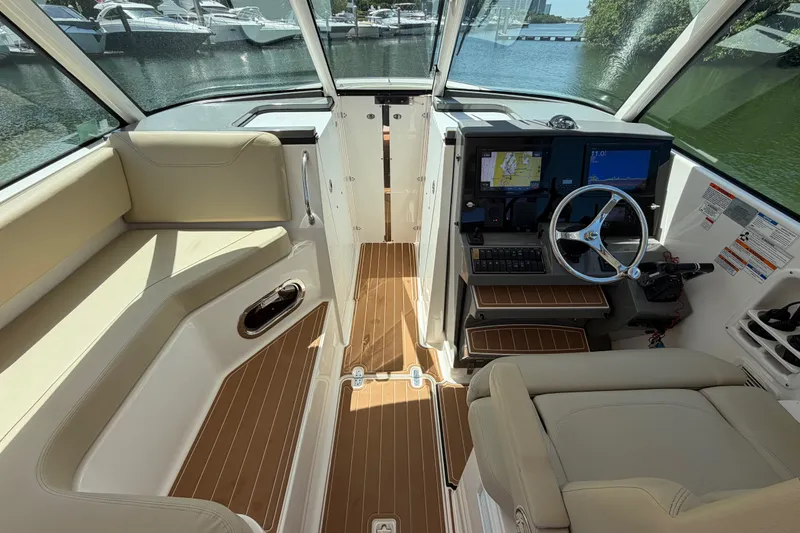 Slide: The Image of 2016 Pursuit DC 325 Dual Console interior with helm, seating, and navigation equipment. - 27
